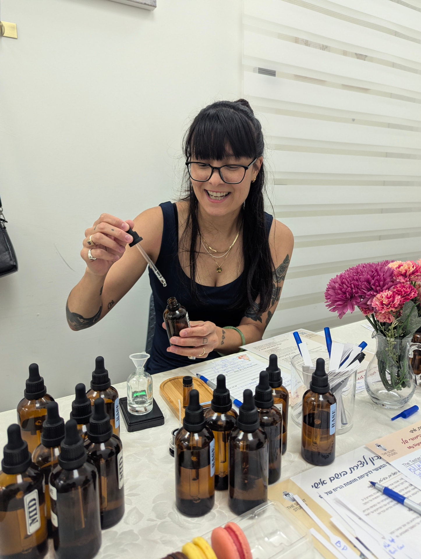 A real guest blending perfume among the studio essences and macarons